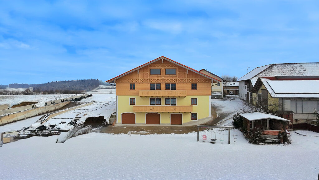 Schneelandschaft mit Ferienwohnungen am Stadlerhof