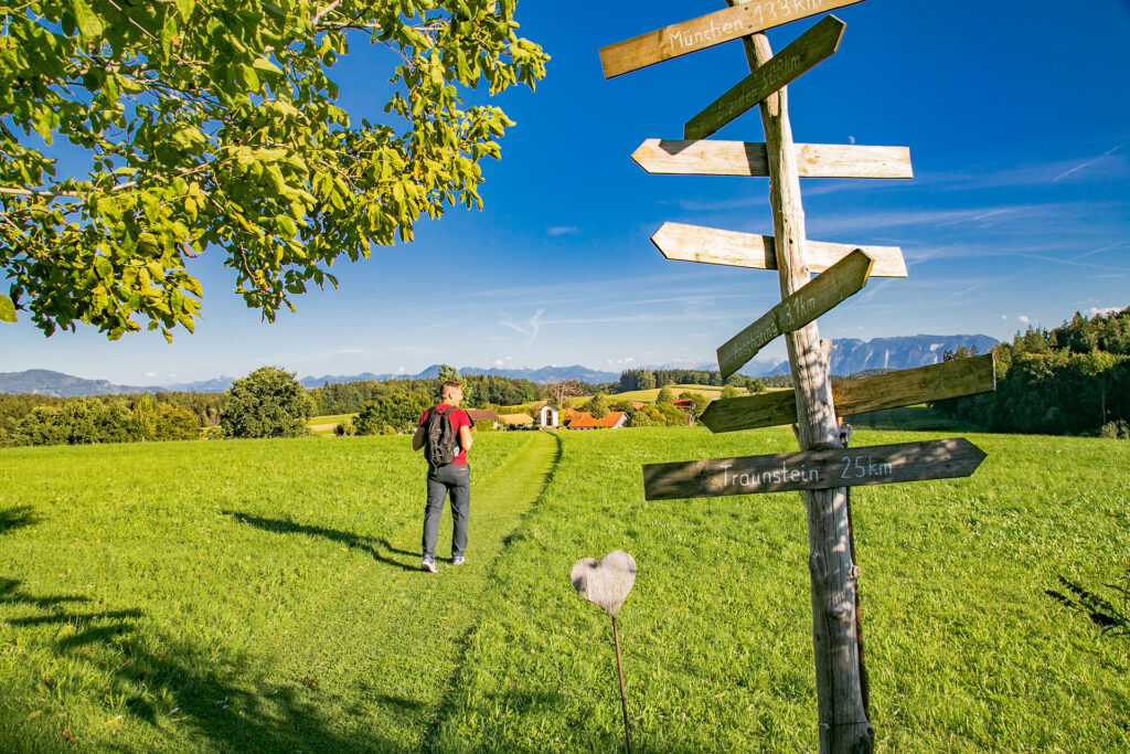 Wanderer im Chiemgau nahe Kirchanschöring Schilder mit Entfernungen Traunstein München