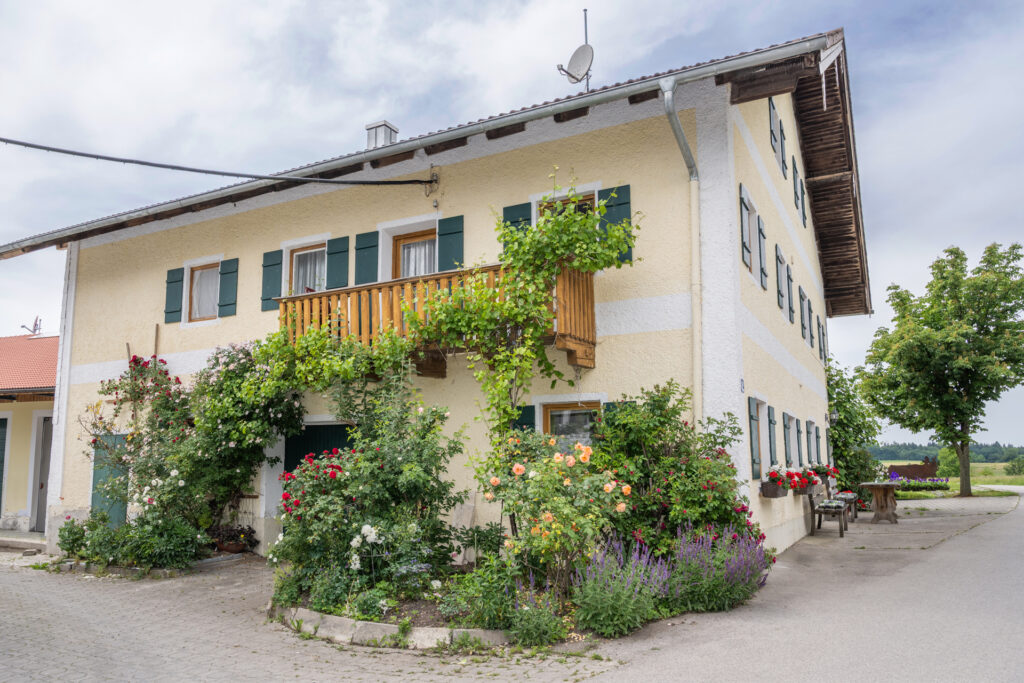 Gästehaus am Stadlerhof Waging am See mit Blumen und Sitzbänken
