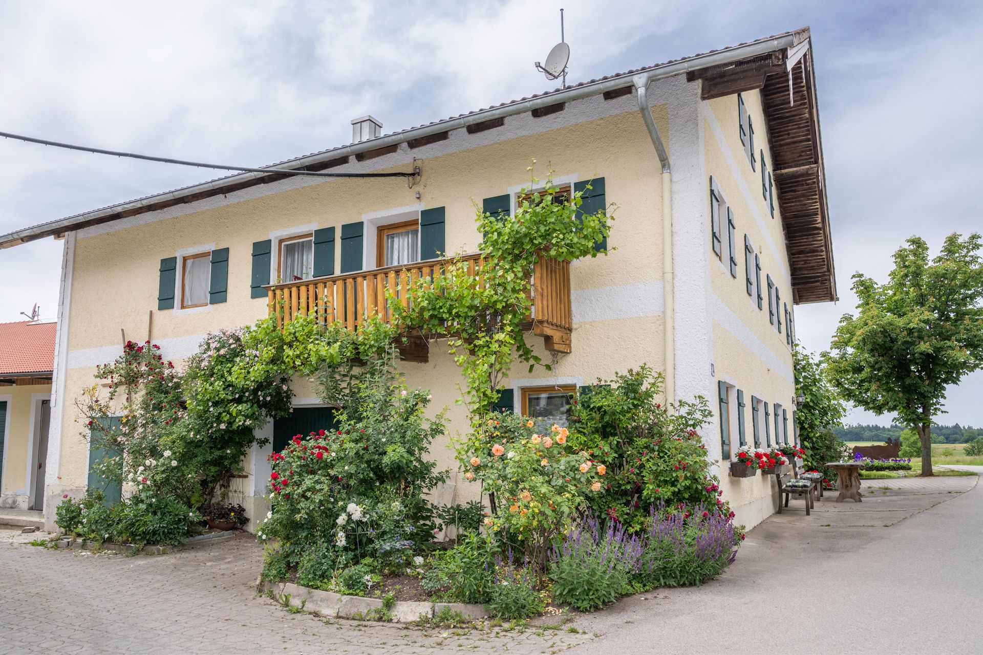 Gästehaus am Stadlerhof Waging am See mit Blumen und Sitzbänken