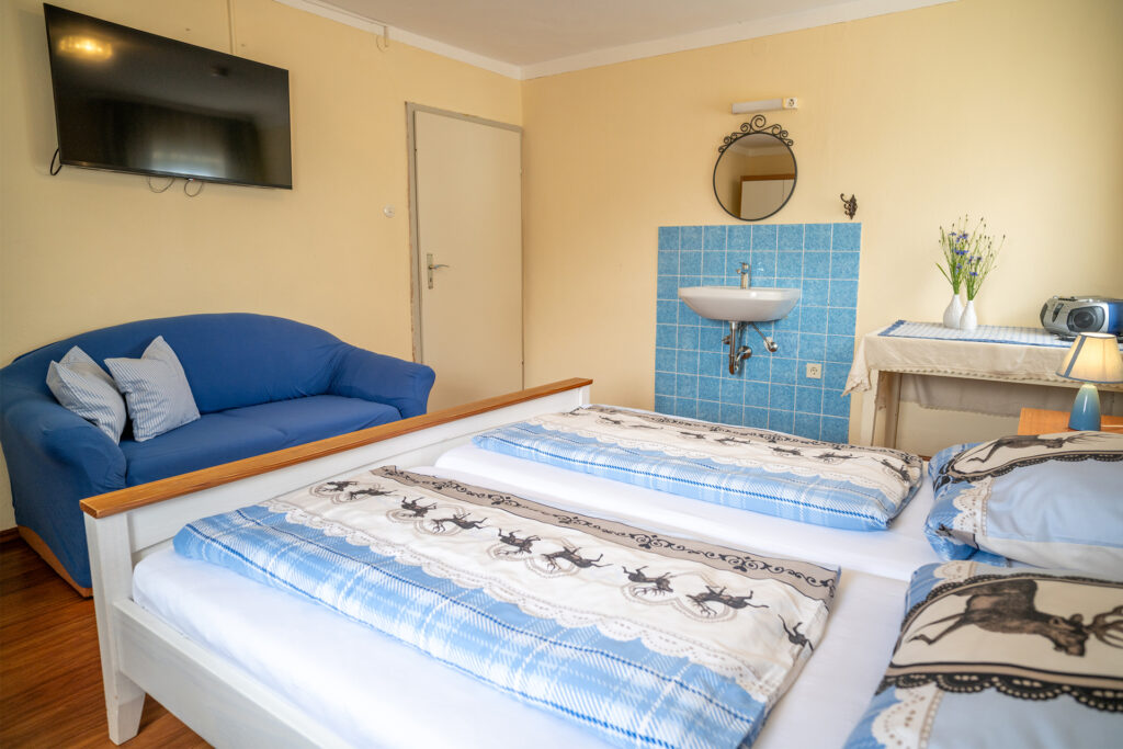 Schlafzimmer mit Doppelbett und Couch in der Ferienwohnung Seeblick