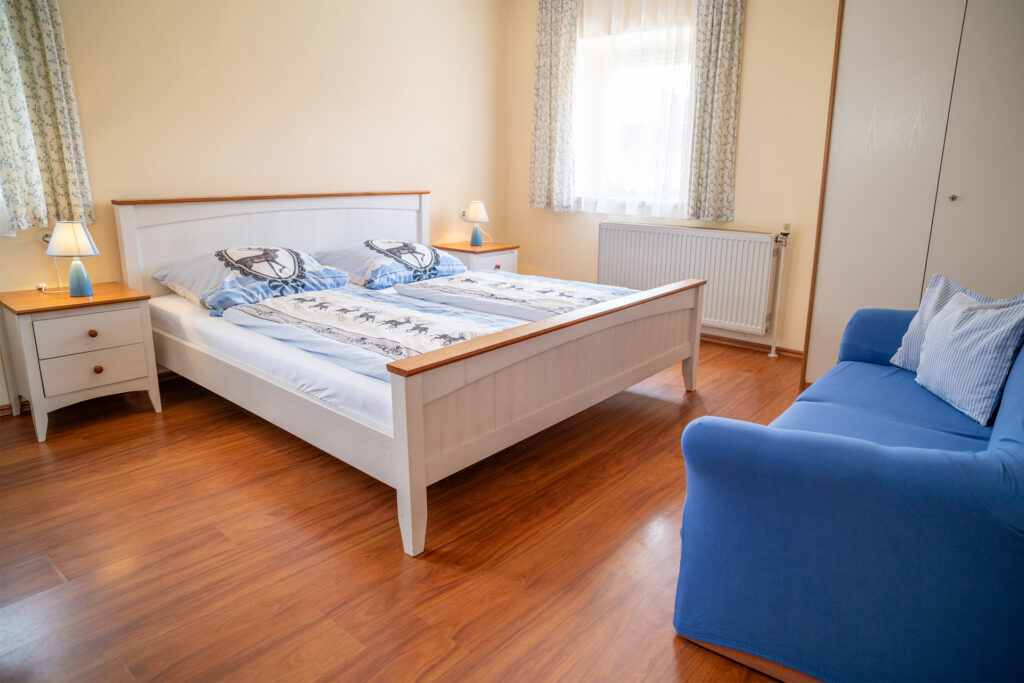 Schlafzimmer in der Ferienwohnung Seeblick mit Doppelbett, Schrank und Couch