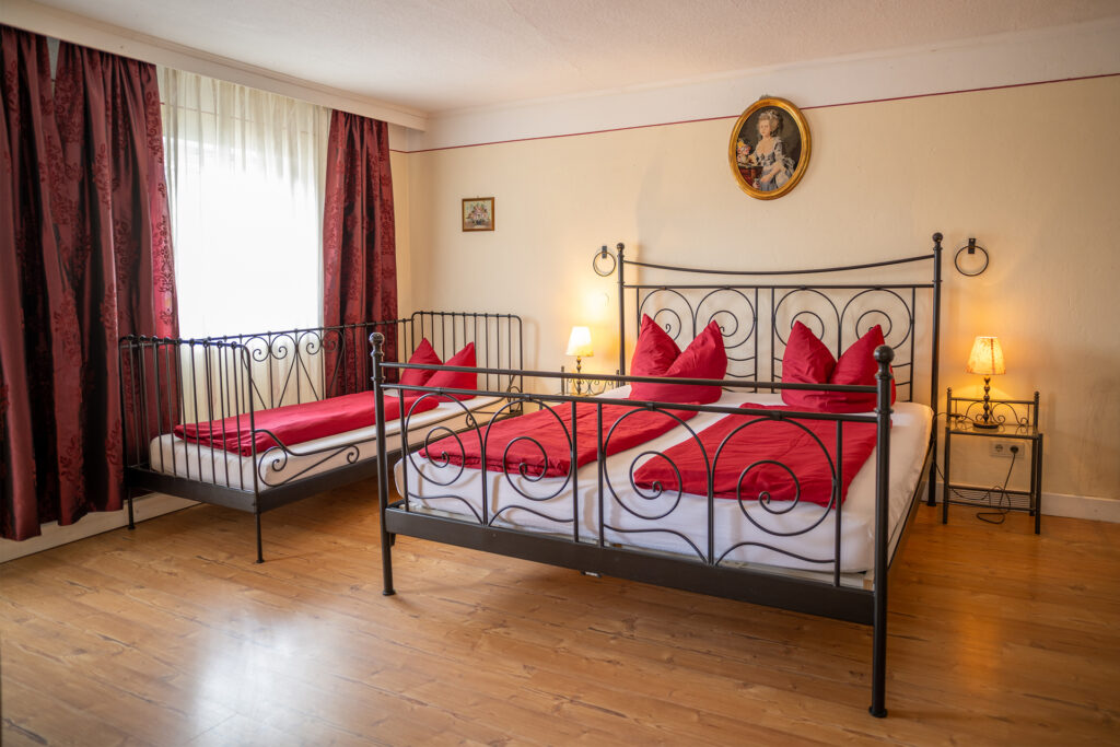 2. Schlafzimmer mit 3 Betten in der Ferienwohnung Rustica und Balkonzugang