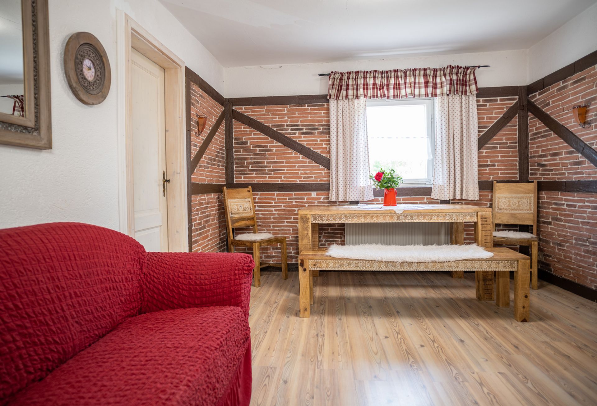 Wohn-Küche-Ferienwohnung-Rustica-Gästehaus-Stadlerhof Geräumige Wohnküche mit einem großen Esstisch Stühlen und einem Sofa in der Ferienwohnung Rustica.