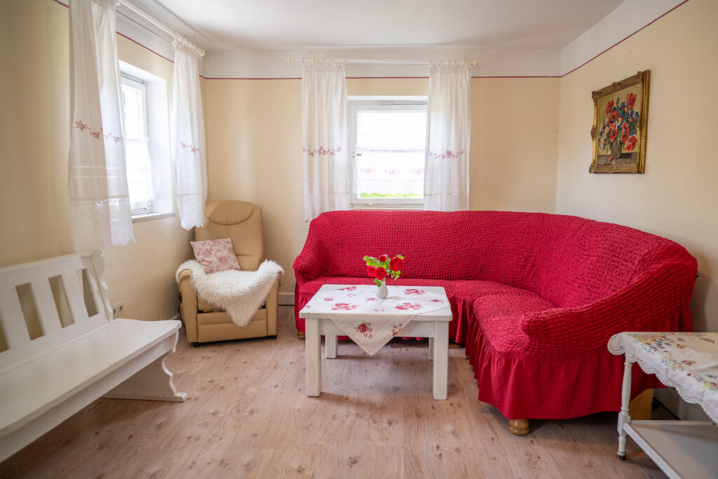 Wohnzimmer, Couch, Sessel und Holzbank in der Ferienwohnung Rustica im Gästehaus
