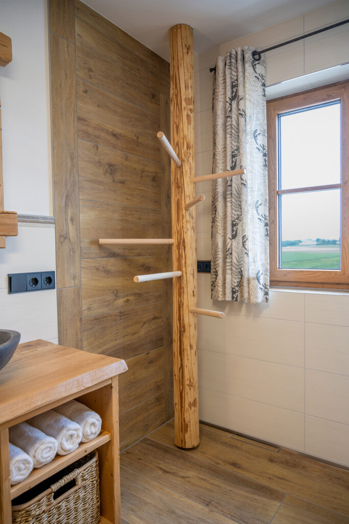 Handtuchhalter aus Holz Rustikal im Landhaus-Style und Fenster mit Blick über die Felder vom Stadlerhof