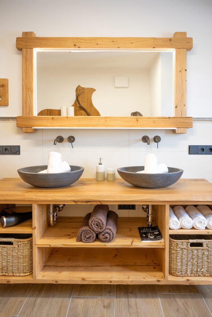 Landhaus-Style im Bad mit Spiegel, Waschbecken, Handtüchern und Ablage-Körbe
