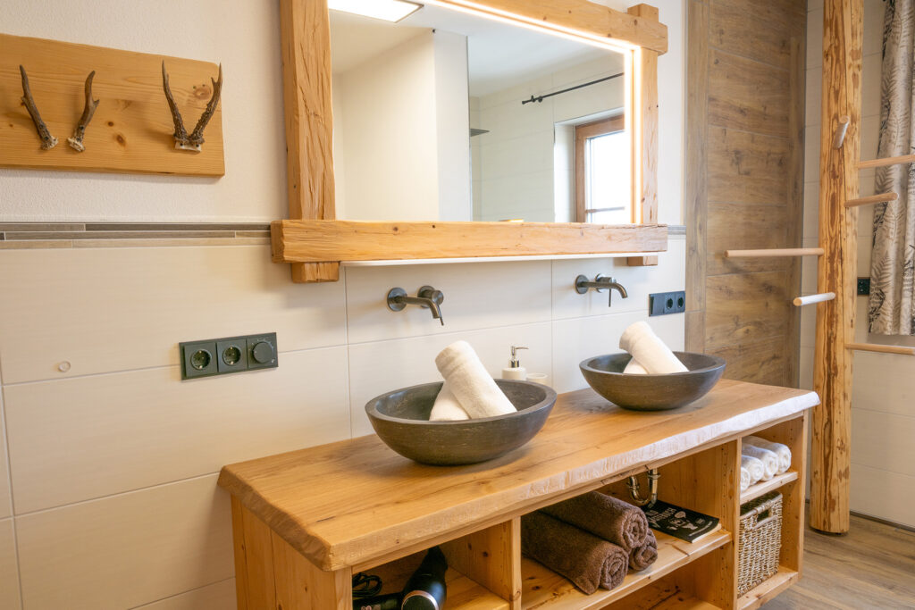 Badezimmer im Landhaus-Style mit Waschbecken, Spiegel, Handtuchhalter aus Holz