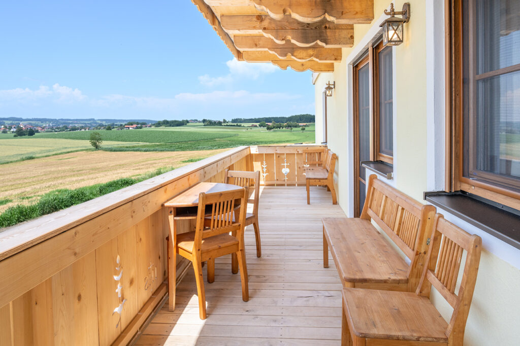 Auf dem Balkon sind Echt-Holzmöbel für gemütliche Urlausstunden auf dem Bauernhof