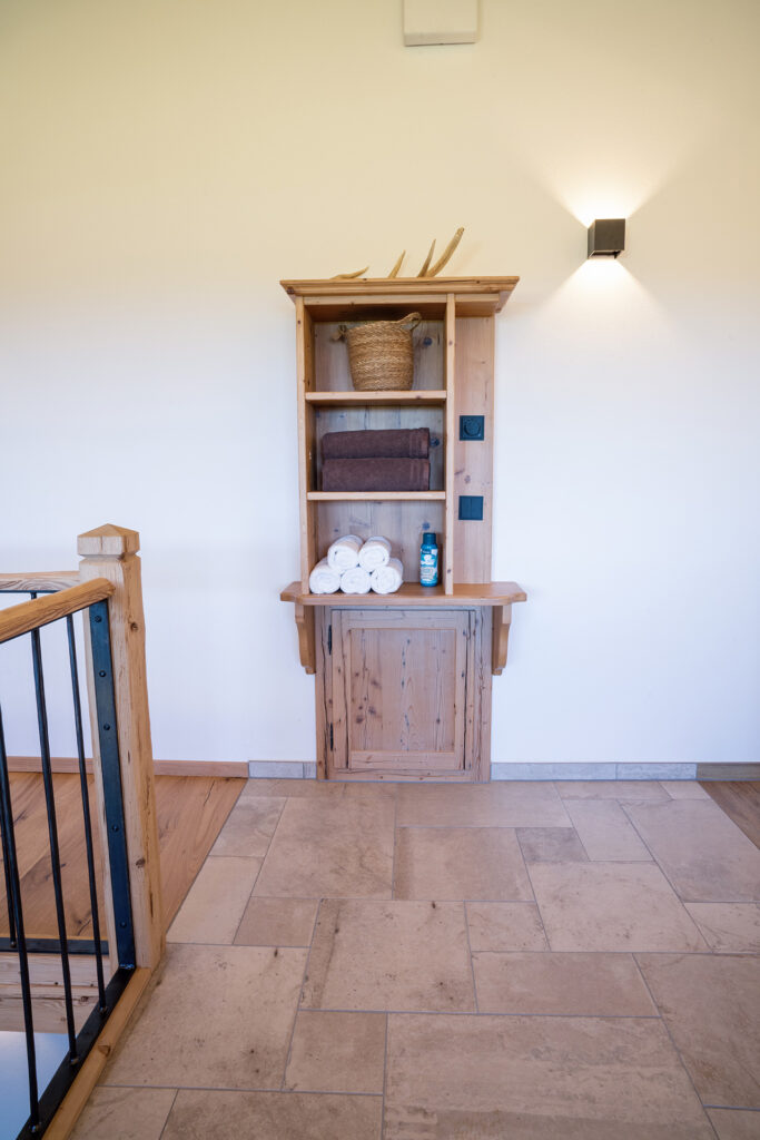 Holz-Schrank in der offenen Galerie mit Handtüchern