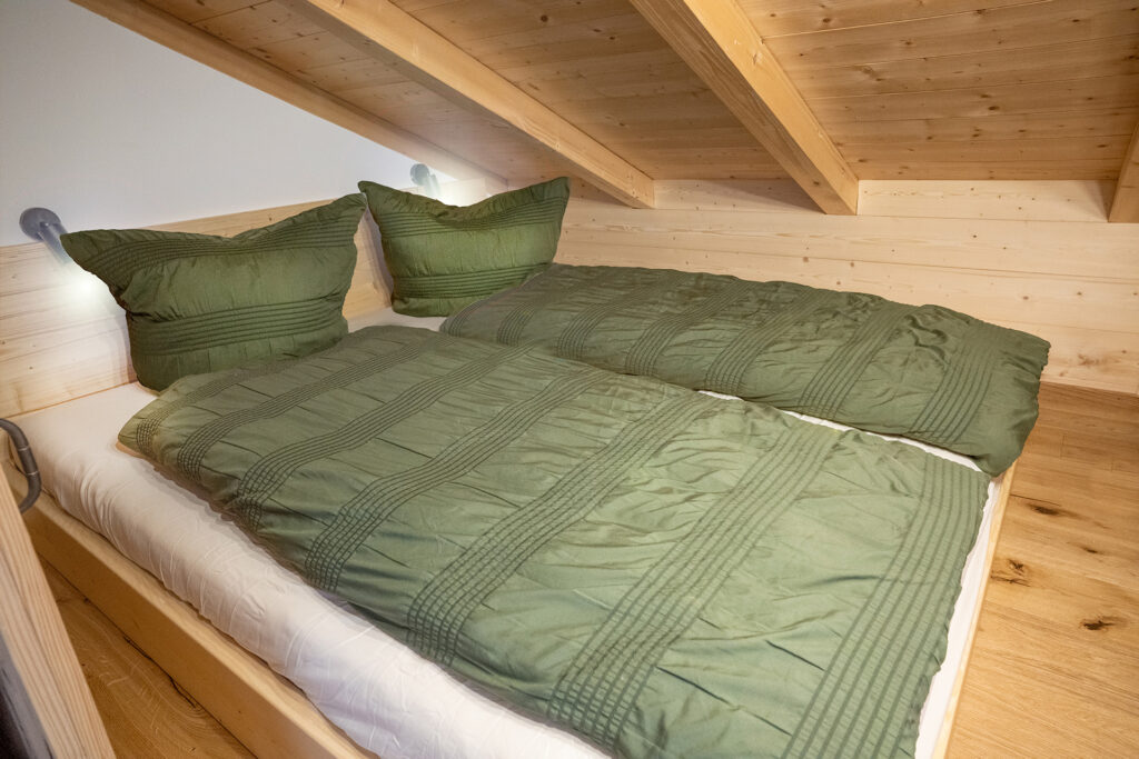 gemütliches Kinderzimmer mit Doppelbett und grüner Bettwäsche