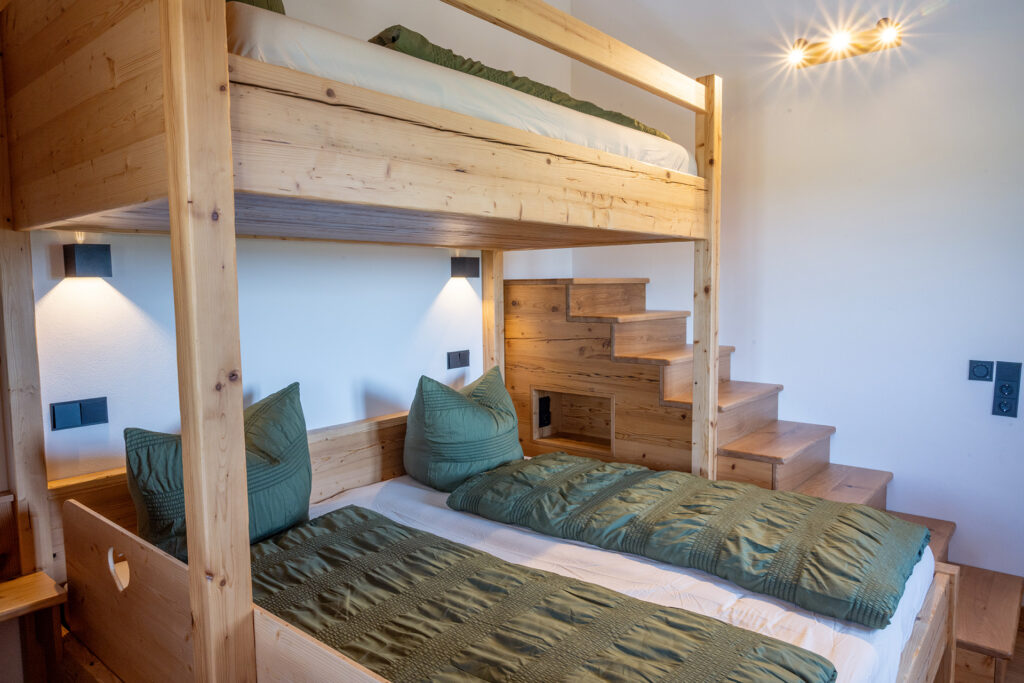 Schlafzimmer mit Doppelbett und Etagenbett - alles rustikal in Holz im Landhaus