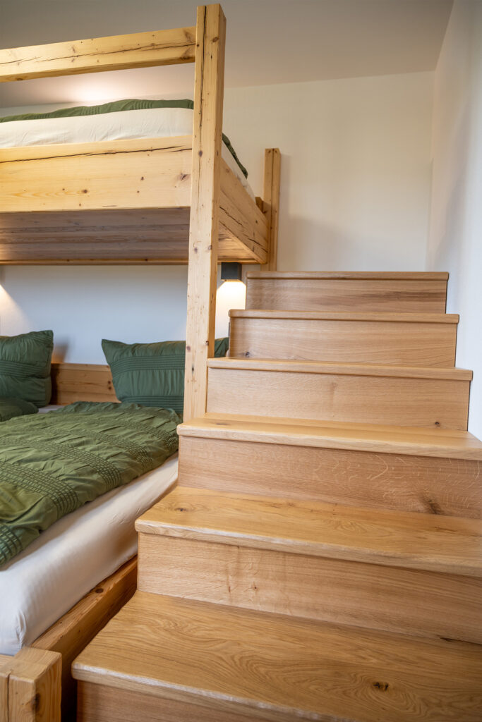 Im Schlafzimmer geht eine Treppe zum Etagenbett Ferienwohnung Bergblick
